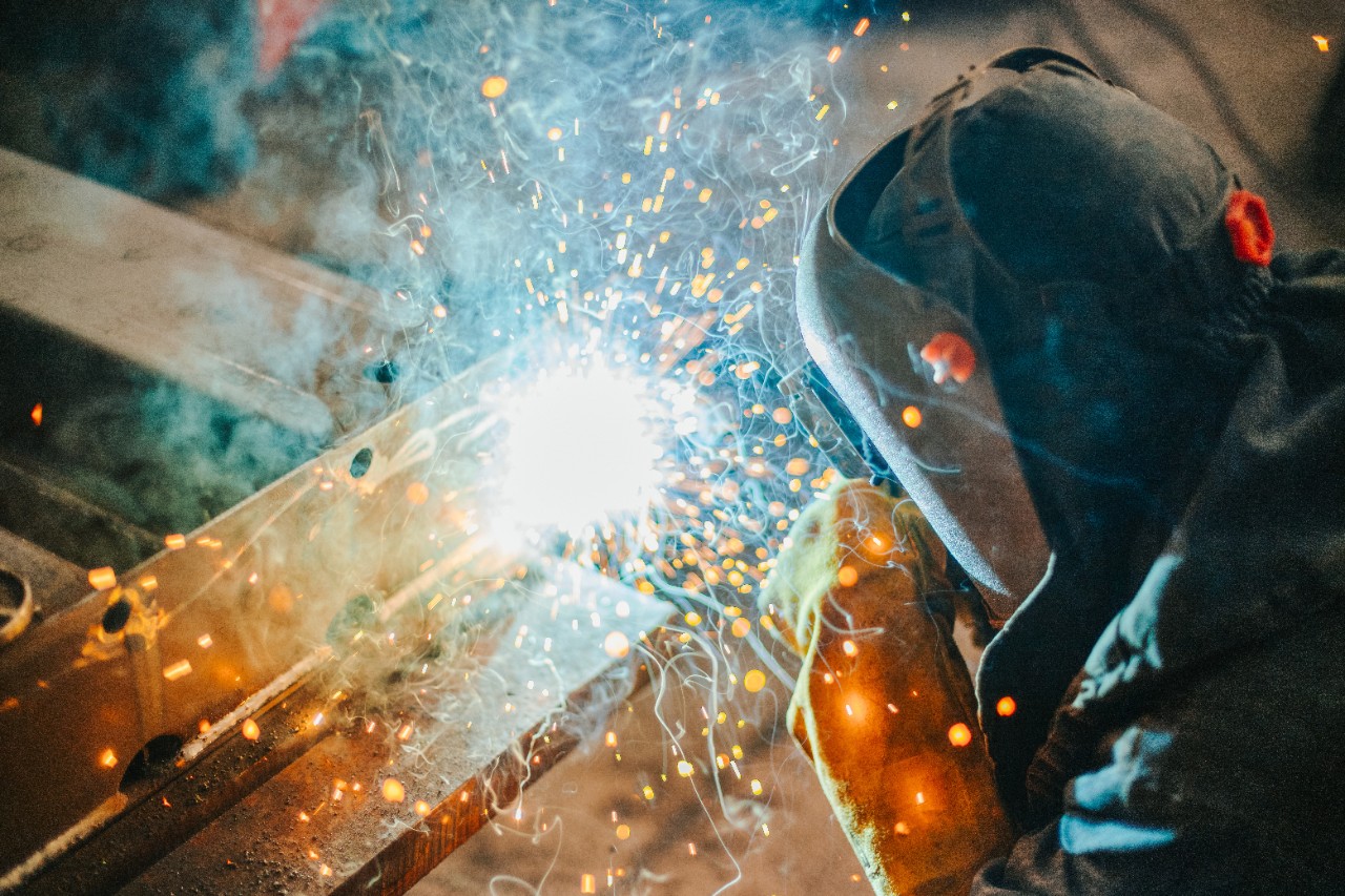 一名焊工在连接两块金属时穿着防护装备。